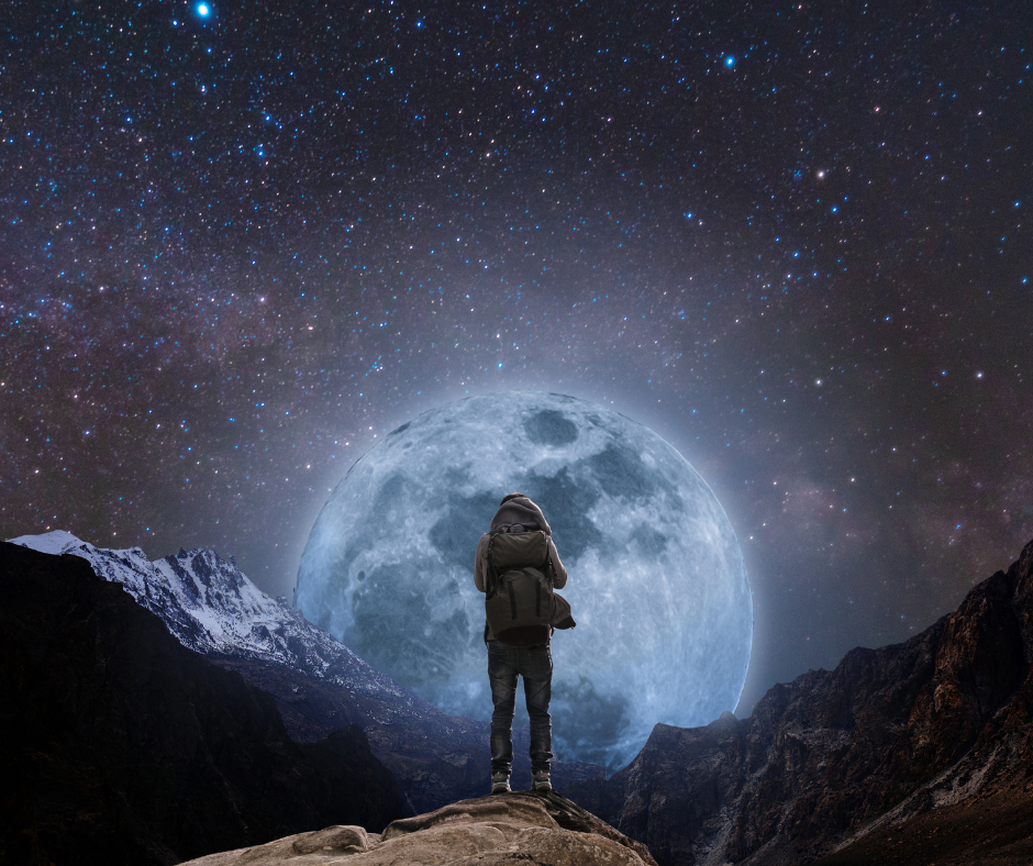 A hiker looking at a full moon