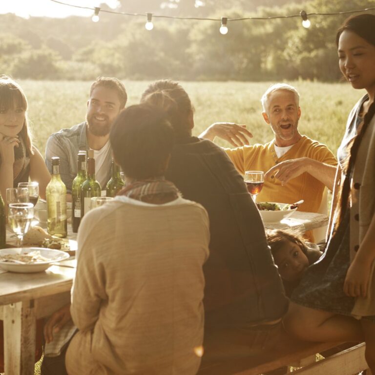 tranquil scene of people gathered around an outdoor dinner table